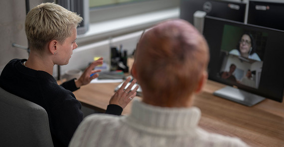 Maxi Woelke und Fabian Arntz sitzen zusammen vorm PC-Bildschirm.