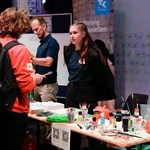 Mitarbeitende des Zentrum für Hochschulsport stehen am Stand und informieren die Studierenden.
