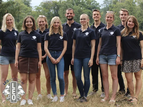 Gruppenfoto mit mehreren Personen auf einer Wiese