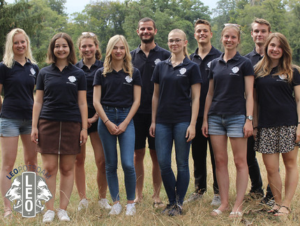 Gruppenfoto mit mehreren Personen auf einer Wiese