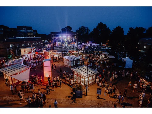 großer Platz mit Personen und Zelten bei Nacht