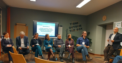 Das Bild zeigt die Podiumsteilnehmenden und den Moderator beim Diskussionsforum.