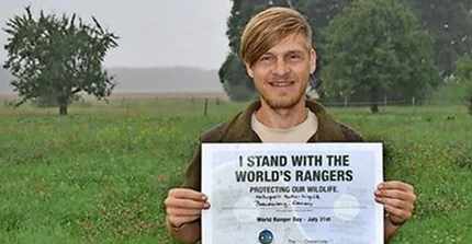 Portrait von Karsten Voigt. Er hält ein Zertifikat in die Kamera "I stand with the world's rangers"