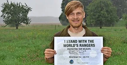 Portrait von Karsten Voigt. Er hält ein Zertifikat in die Kamera "I stand with the world's rangers"