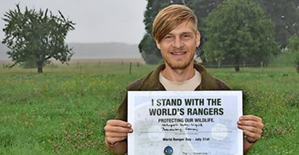 Portrait von Karsten Voigt. Er hält ein Zertifikat in die Kamera "I stand with the world's rangers"