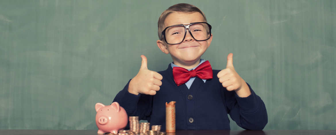 child in front of a piggy bank and some coins - 