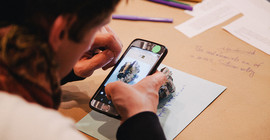 Eine Person schaut auf ein Smartphone.