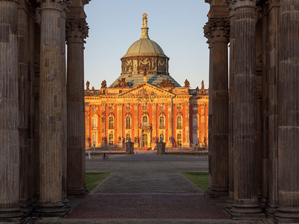 Das Neue Palais gesehen durch die mittleren Säulen der Kolonnade