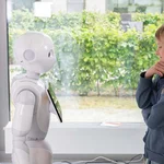 Ein Kind steht einem Roboter gegenüber