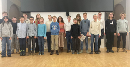 Kinder verschiedener Altersgruppen posieren für ein Gruppenfoto.