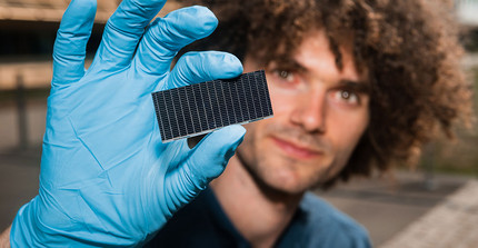 Der Physiker Felix Lang hält eine Solarzelle.