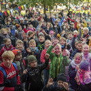 Viele Kinder stehen vor der Bühne und strecken vor Freude die Arme in die Luft.