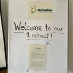 Das Foto zeigt ein Flip-Chart mit der Aufschrift "Welcome to our 1. retreat" sowie dem Logo des UFS "Education for the Future" und dem Zeitplan für das Retreat.