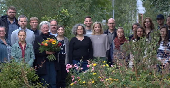 Fast 20 Vertretende verschiedener Einrichtungen Brandenburgs posieren für ein Gruppenbild im Campusgarten der FH Potsdam.