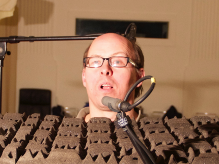 Frank Kane shown behind microphone