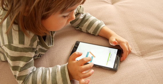 Kleinkind spielt mit Smartphone.