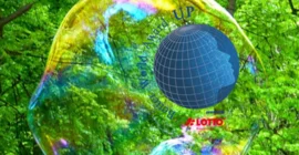 Ein Globus umgeben mit Schrift "Better World Award" und "powered by Lotto Brandenburg". Im Bildhintergrund das grüne Laubdach eines Waldes und große Seifenblasen.