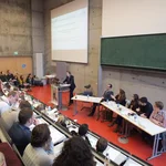 Professor Lammers mit Studierenden auf dem Podium