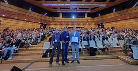 Prof. Thorsten Wagener, Ph.D. (Mitte) bei der Preisverleihung in Wien in einem großen Auditorium.