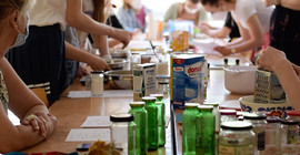 Schülergruppe an einem Tisch beim experimentieren und anfertigen von nachhaltigen Alltagsprodukten.