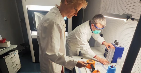 Two people preparing the sample holder for cryo-electron microscopy.