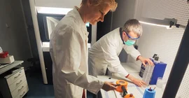 Two people preparing the sample holder for cryo-electron microscopy.