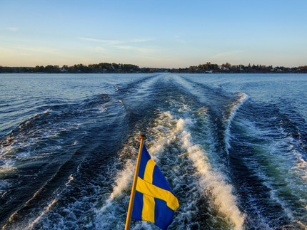 Boot fährt auf See mit schwedischer Flagge