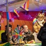 Mehrere Personen an einem Marktstand mit bunten Wimpeln