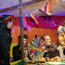 Mehrere Personen an einem Marktstand mit bunten Wimpeln