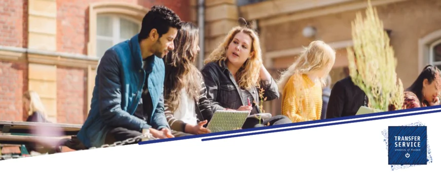 Studierende sitzen auf einer Bank am Campus Neues Palais und unterhalten sich. Eine Studentin hat einen Laptop auf dem Schoß.