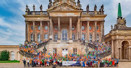 Gruppenfoto vieler Studierender auf der Treppe des Südcommuns