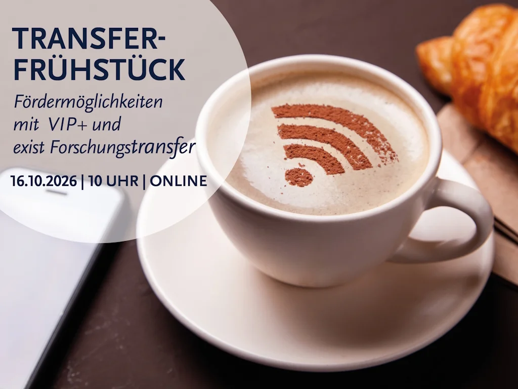 Eine Tasse Kaffee mit einem WLAN-Symbol im Milchschaum und ein Croissant mit einem Smartphone im Hintergrund.