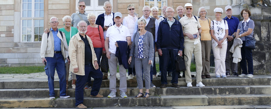 Alumni posieren für ein Gruppenfoto vor Haus 9 am Neuen Palais