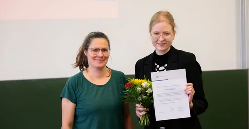 Maisa Mattaila erhält von der Studiendekanin eine Urkunde für die beste Masterarbeit an der Philosophischen Fakultät