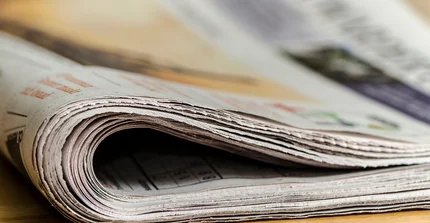 eine zusammengerollte Zeitung in Nahaufnahme von der Seite