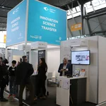 Menschen an einem Messestand stehend