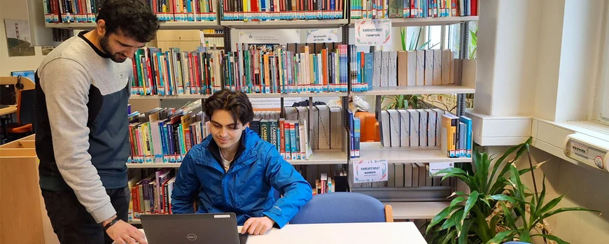 Arbeitssituation des Praktikanten mit einem Kollegen am Laptop