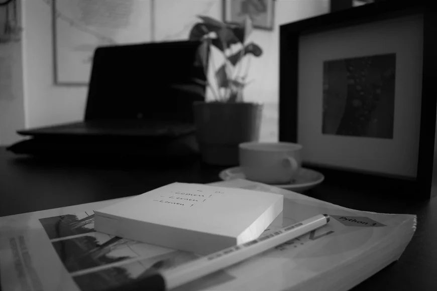 Block auf Buch auf Tisch mit Laptop