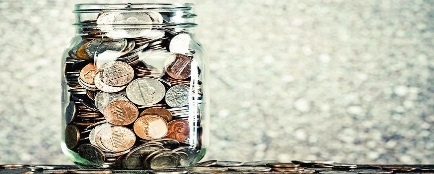 a glass filled to brimming with coins