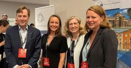 Vier Menschen stellen sich auf eine Bildungsmesse für ein Gruppenfoto zusammen