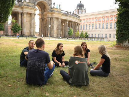 Gruppenfoto mit mehreren Personen auf einer Wiese