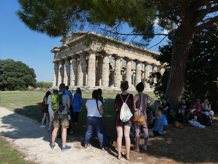 Studierende vor einem griechischen Tempel in Kampanien, Süditalien