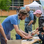 Kinder und Erwachsene an einem Tisch machen Holzstempel