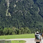 Menschen vor beeindruckender Berglandschaft.