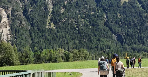 Students walking towards the museum. In the background: mountain side