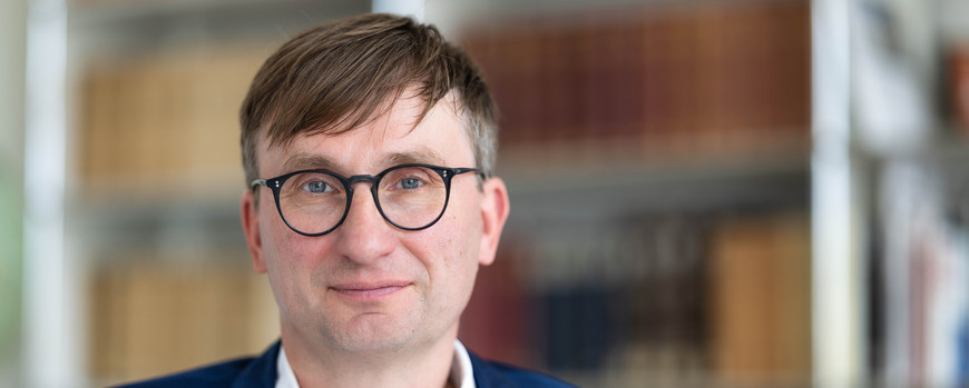 Portrait von Professor Dr. Sönke Neitzel vor einem Bücheregal