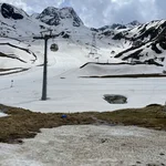 Field site Dresdner Hütte: Montane landscape with patchy snow pattern. In the landscape is measuring equipment, a ski lift and a scientist with a tripod | Photo: Cosmic Sense Consortium