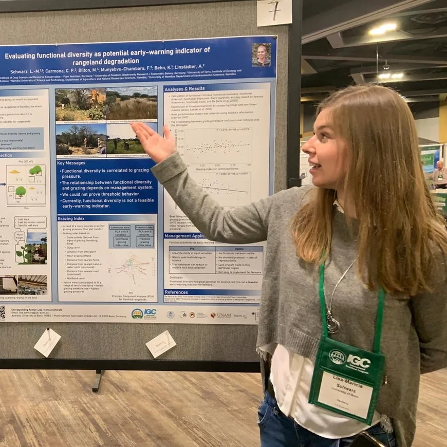 A Woman is standing in front of a poster presentation.