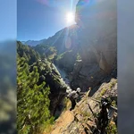 Eine Person klettert an einem steilen Hang.