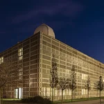 Three-storey high, golden building with observatory at night